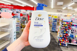 hand holding large dove body wash in a store aisle