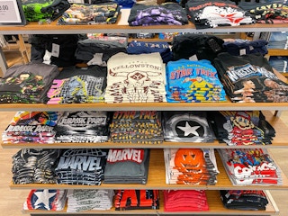 A variety of Disney Graphic Tees folded on a shelf