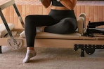 The bottom half of a woman who just finished working out, wearing a pair of black full-length stretch leggings.