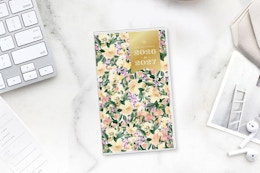 lifestyle image of a planner on a counter near a computer