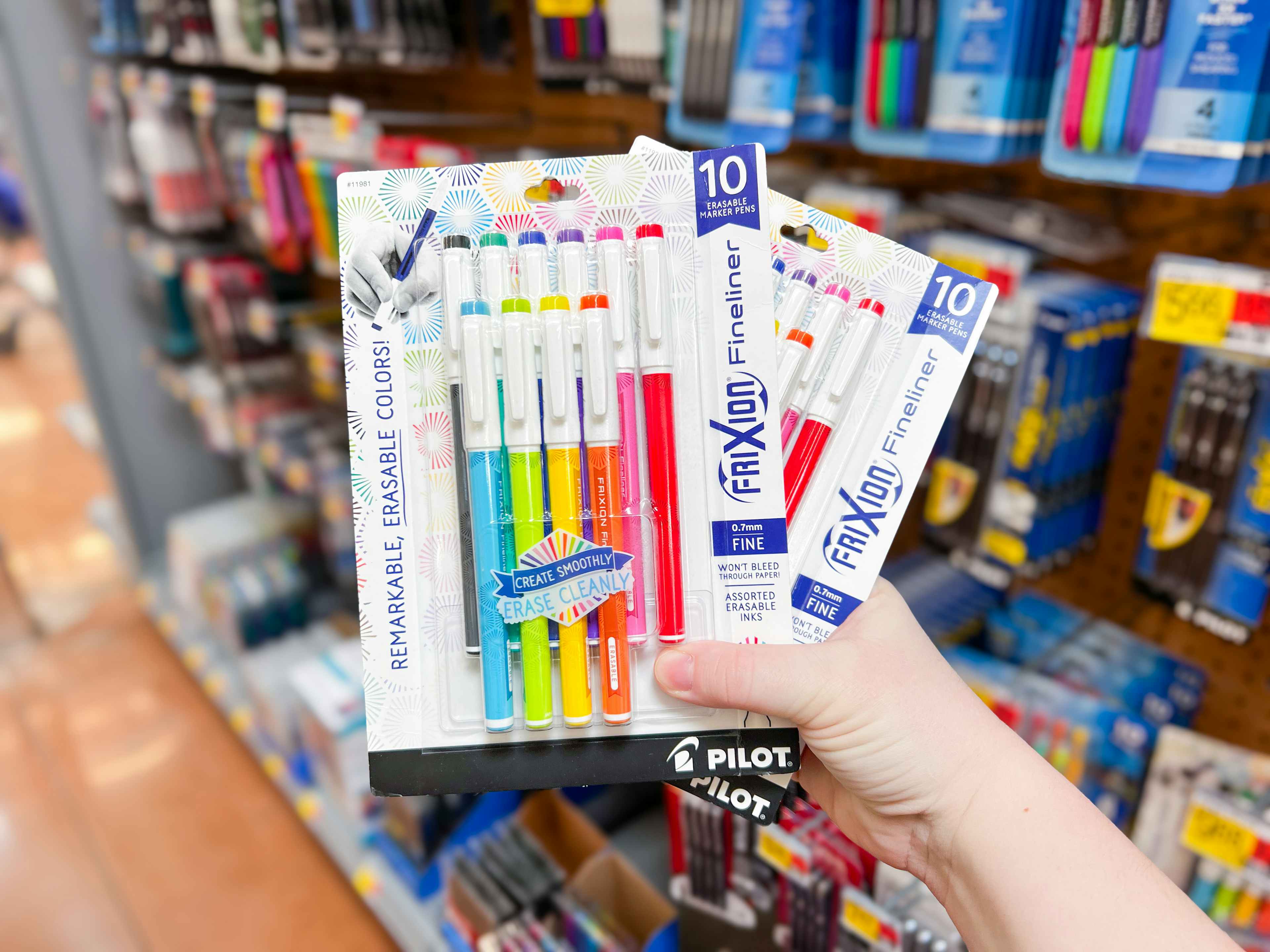 person holding 2 10-packs of pens
