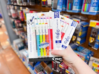 person holding 2 10-packs of pens