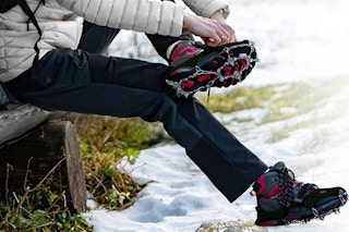 a woman putting on crampons