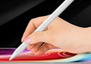 a hand writing on an iPad with a stylus pen