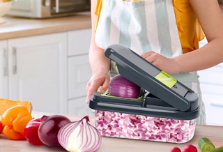a person chopping an onion in a vegetable chopper