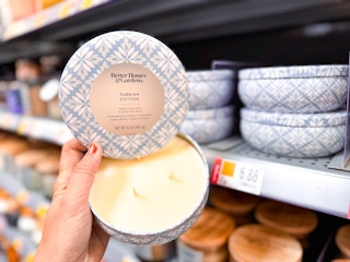 Better Homes & Gardens Candle held up with lid off in candle isle of Walmart