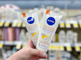 hand holding two tubes of firming cream