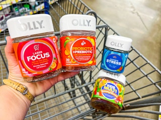 hand holding Olly Focus and Probiotic+Prebiotic contains in front of the Stress and Kids' Multi bottles