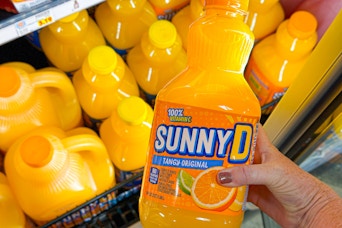 hand holding a bottle of sunnyd juice