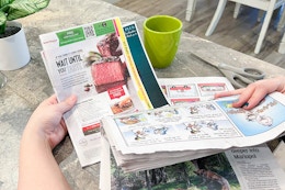 a person pulling a SmartSource coupon insert out of newspaper