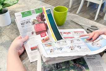 a person pulling a SmartSource coupon insert out of newspaper
