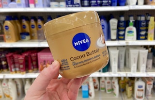 hand holding nivea cocoa butter cream 