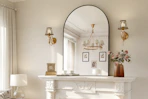 arched wall mirror on top of a fireplace in a living room