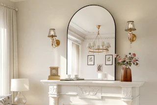 arched wall mirror on top of a fireplace in a living room