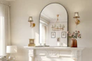 arched wall mirror on top of a fireplace in a living room