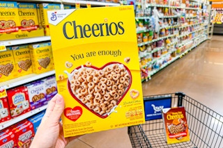 hand holding a box of general mills cereal