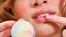 a person putting lip balm on their lips