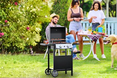 Lifestyle image of the Cowsar 2 burner gas grill in outdoor backyard family setting