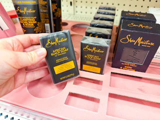 hand holding sheamoisture bar soap in front of target shelf