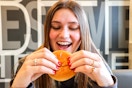 a person taking a bite of a mcdonalds hamburger