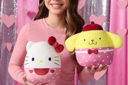 a girl holding sanrio squishmallows