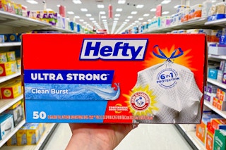 hand holding a box of hefty ultra strong trash bags in a target aisle