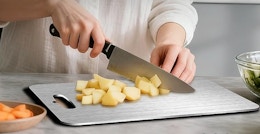 a persoon chopping on a titanium cutting board