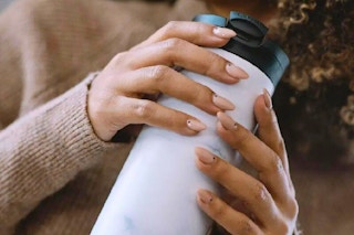 a woman holding a contigo mug
