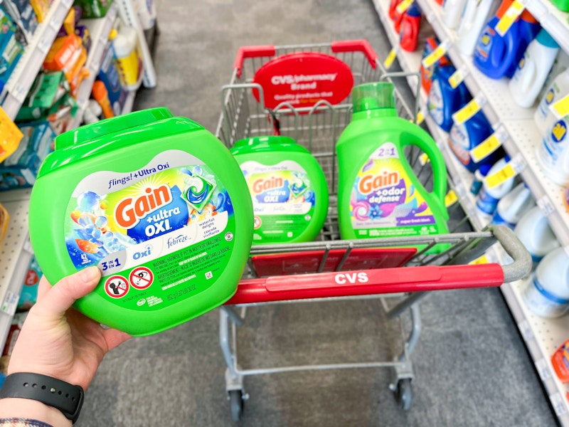 person holding gain flings over a cart with more gain detergent
