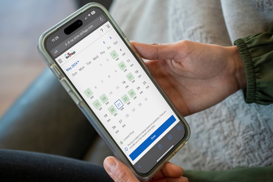 a person on their phone, selecting a date for six flags tickets