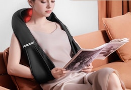 a person sitting with a neck massager on their neck
