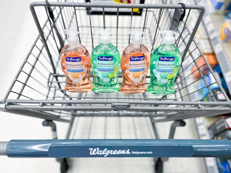 four bottles of Softsoap hand soap sitting in the basket portion of a Walgreens cart