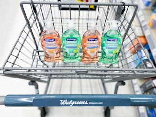 four bottles of Softsoap hand soap sitting in the basket portion of a Walgreens cart