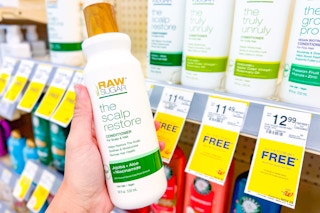 person holding a bottle of raw sugar conditioner by a bogo free sign