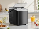 an ice maker on a counter with drinks and a plate of food