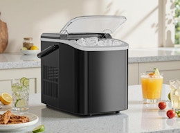 an ice maker on a counter with drinks and a plate of food