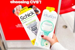 person holding 2 schick razors