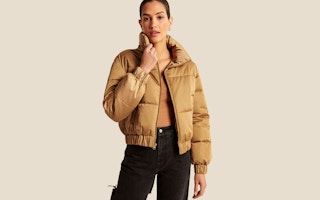 a woman wearing a tan puffer jacket