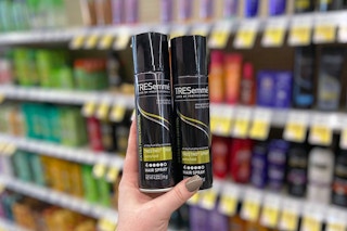 hand holding two cans of Tresemme Tres Two hair spray in aisle