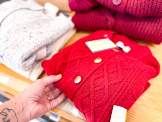 hand holding a red women's sweater