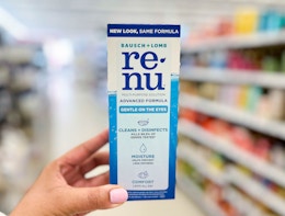 hand holding a box of Renu advanced multi-purpose solution in aisle