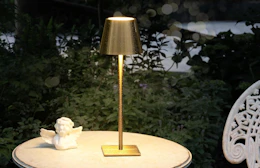 a gold table lamp on a table 