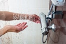Hand turning on water from a shower