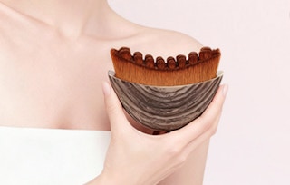 a person holding a lymphatic face brush