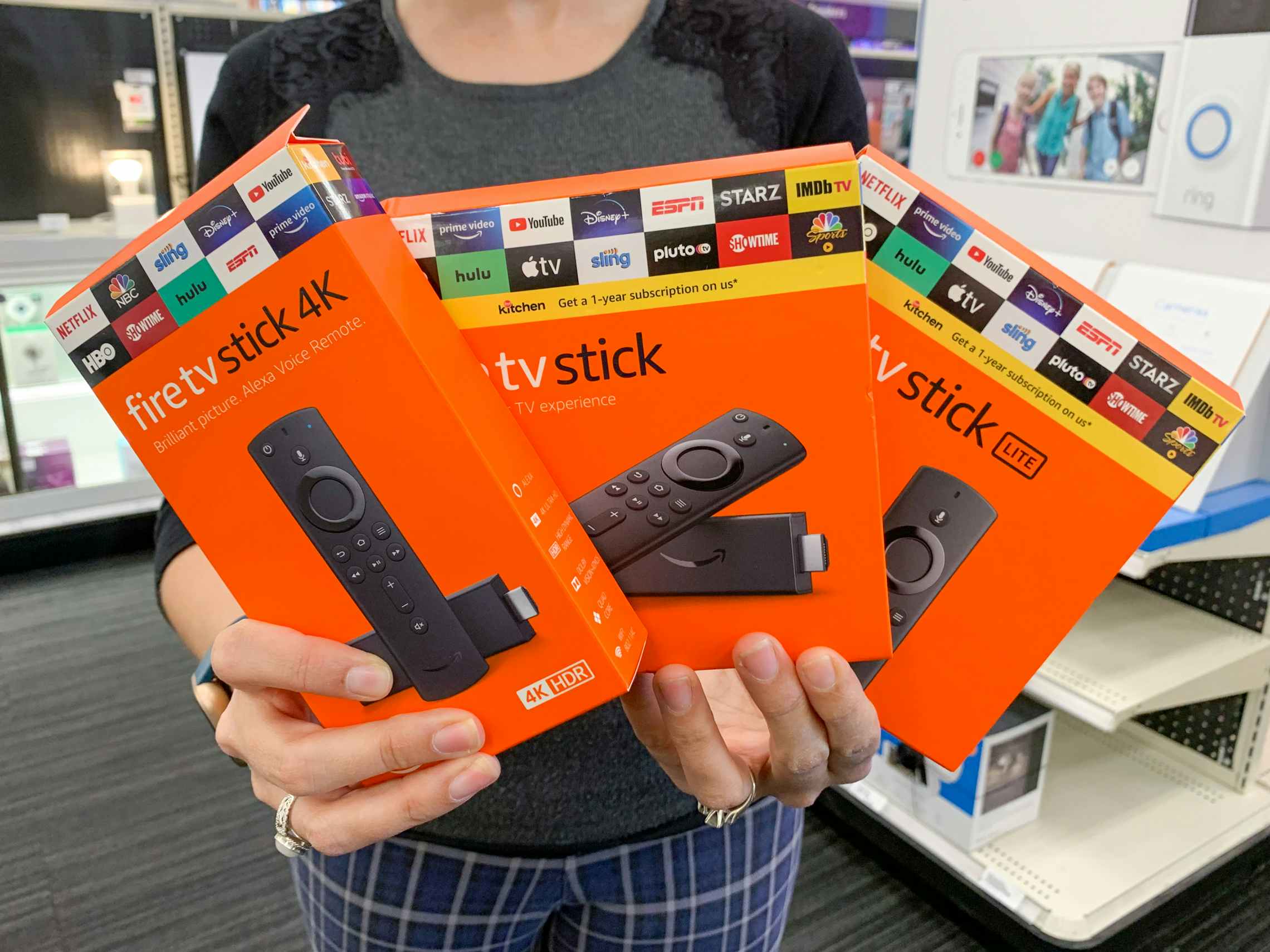 a person holding up three fire tv sticks