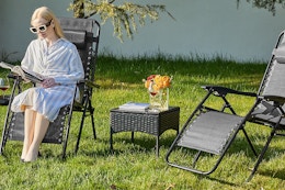 a woman sitting on zero gravity chairs