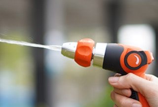 an orange and black sprayer squirting water