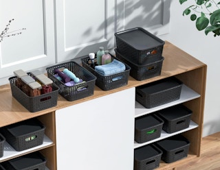 storage bins with objects on shelves against a wall