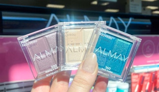 hand holding three almay eye shadows
