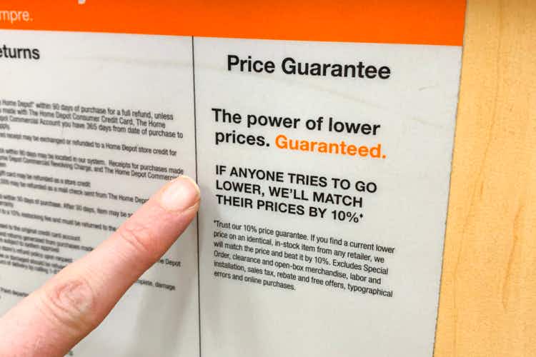 Finger pointing to sign that says, "Price Guarantee. The power of lower prices. Guaranteed." 